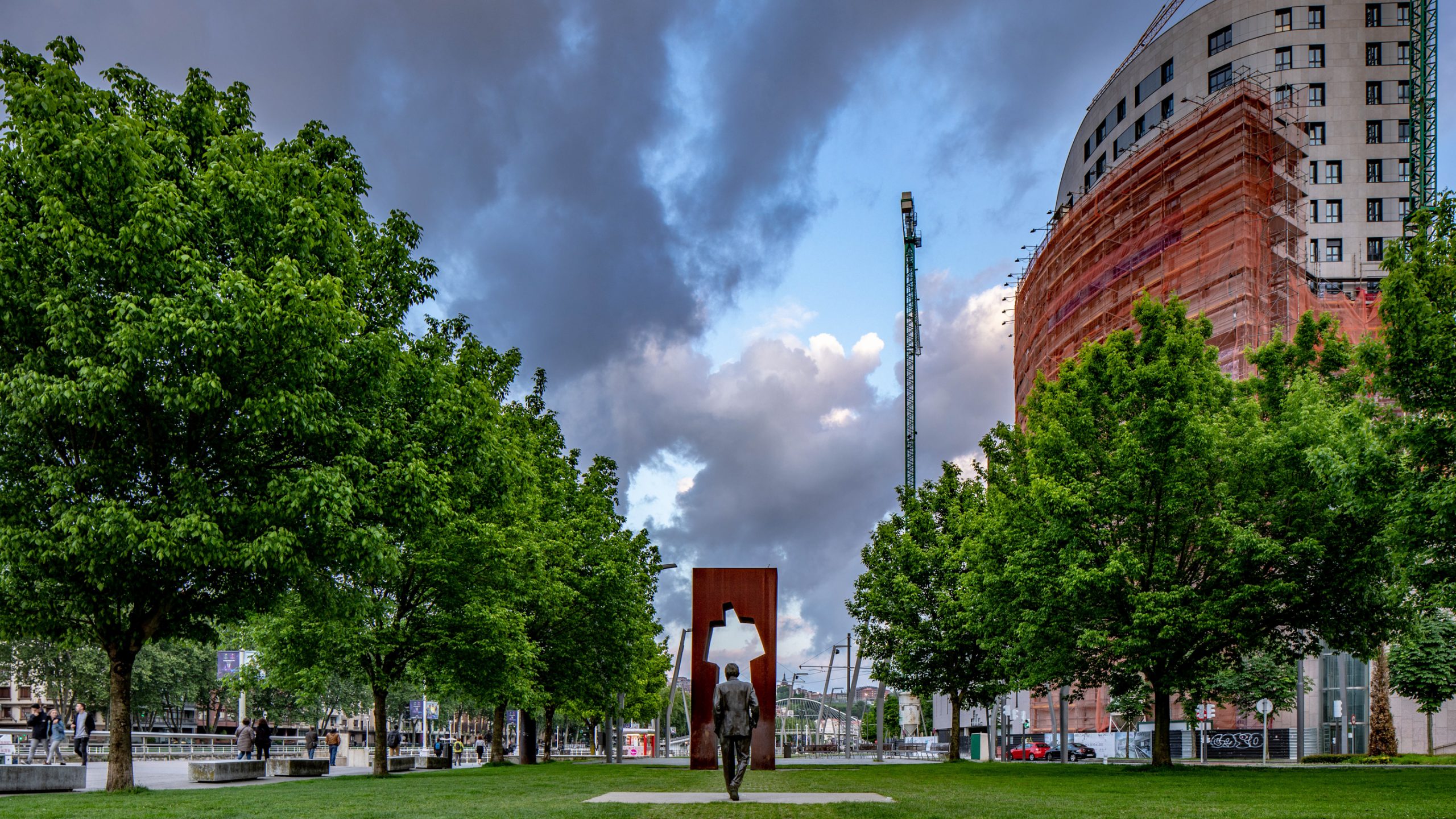 Statue de bronze devant arche Corten