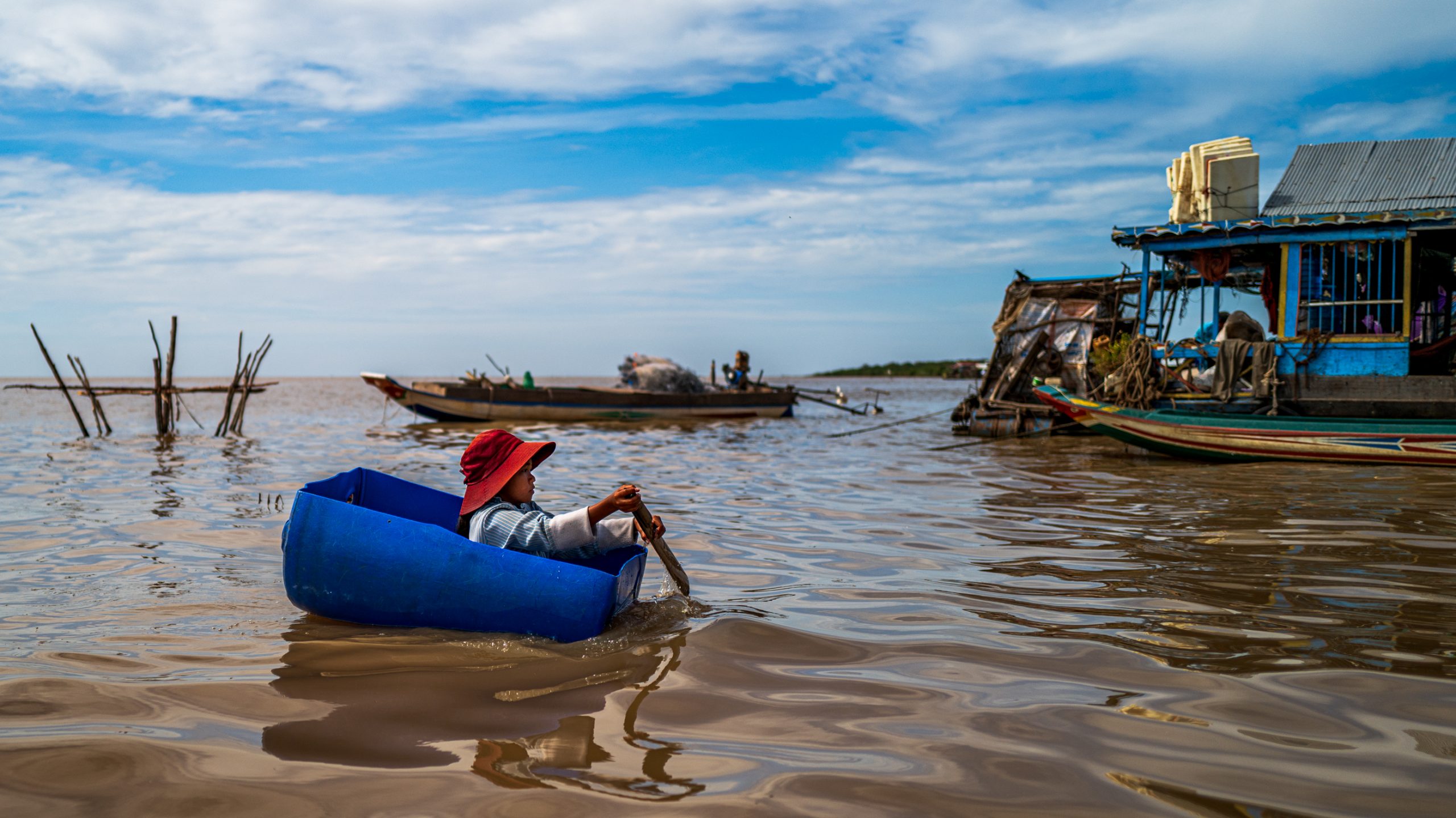 Enfant pagayant dans bac bleu