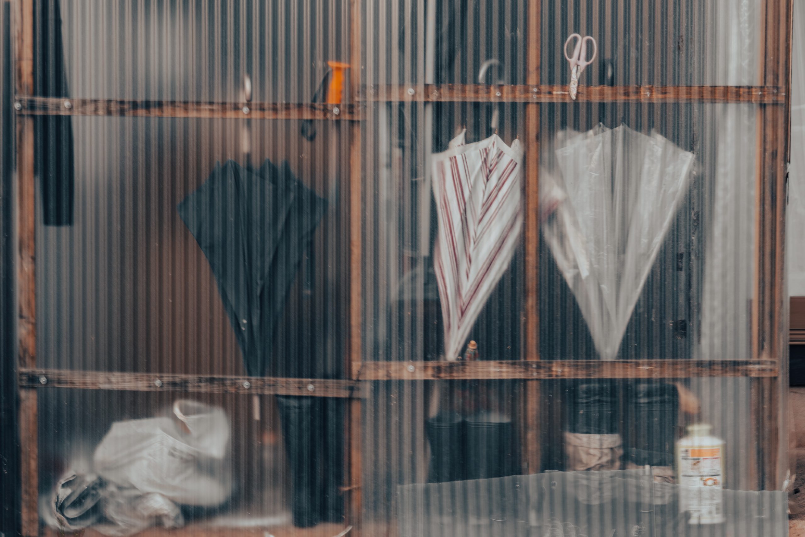 Parapluies derrière paroi ondulée